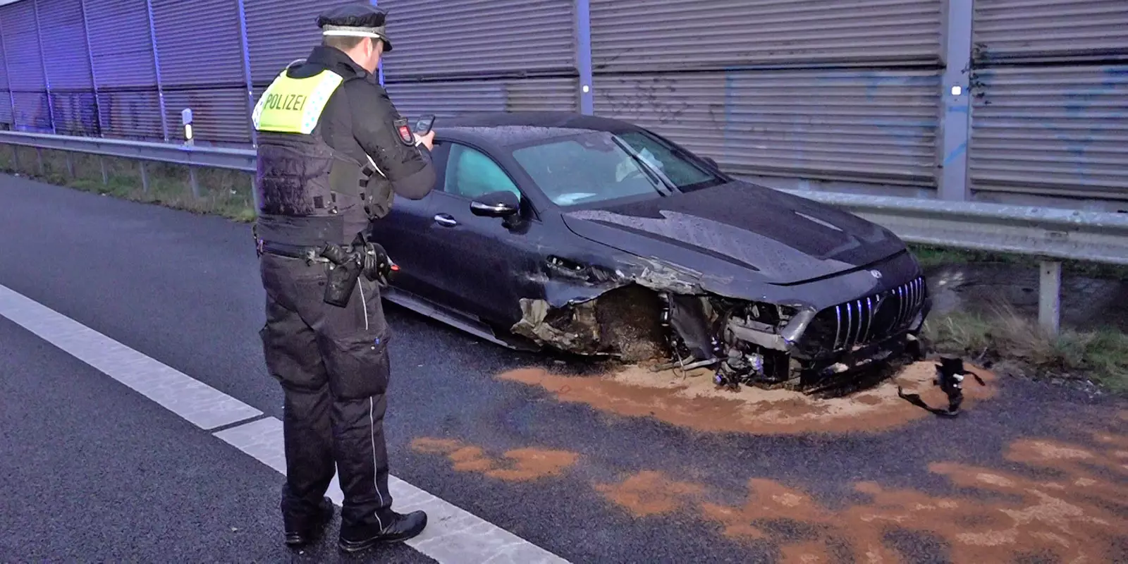 Ein Polizist fotografiert den Schaden am Auto. Foto: Lenthe-Medie