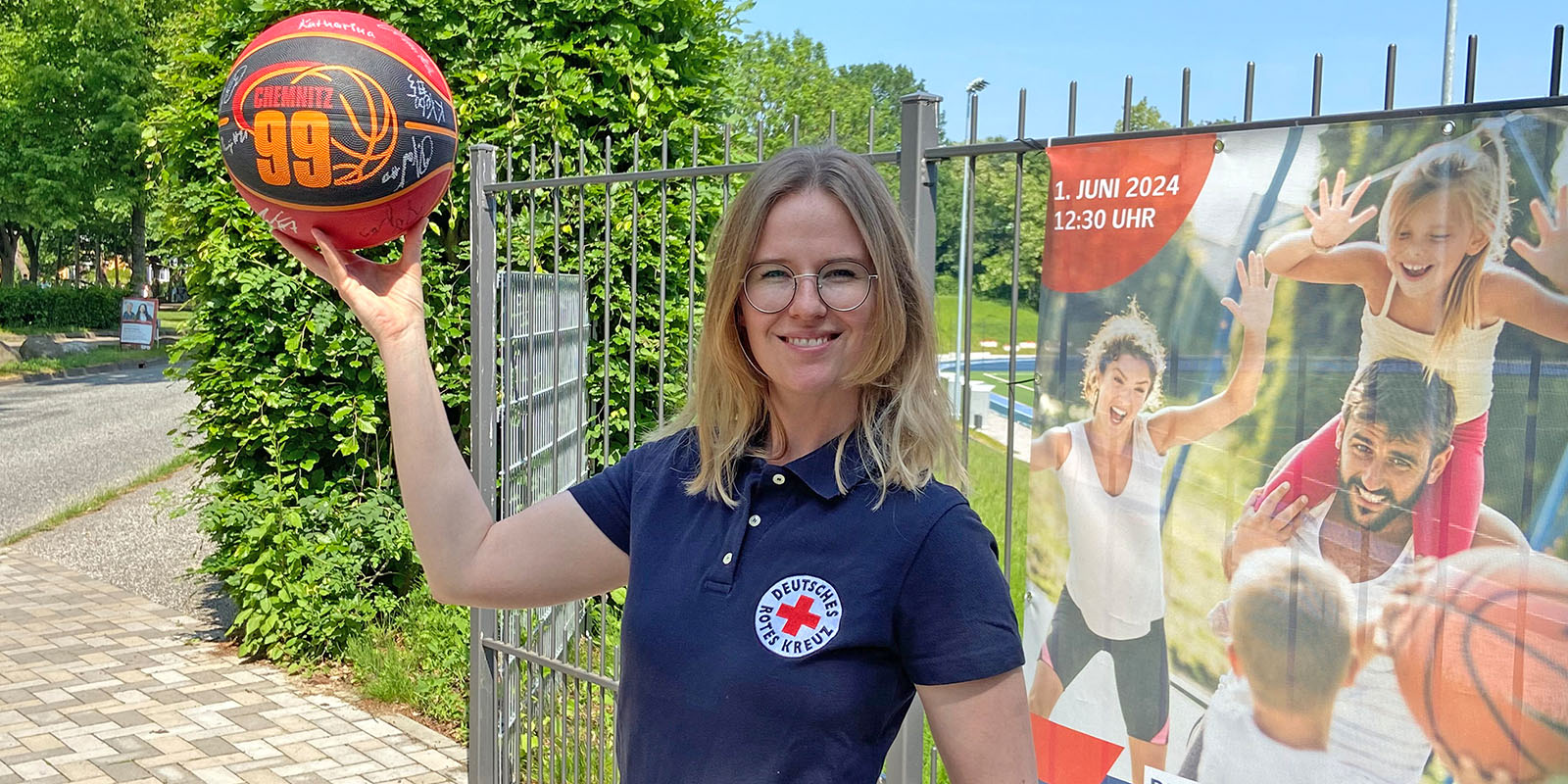 DRK-Spendenbeauftragte Viktoria Ehlers mit dem signierten Basketball, der bei der Eröffnung des Sportparks versteigert werden soll. Foto: pr
