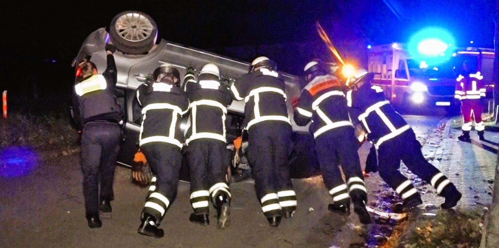 Mit vereinten Kräften stellten Feuerwehrleute das umgekippte Auto wieder auf die Räder. Foto: Lenthe-Medien