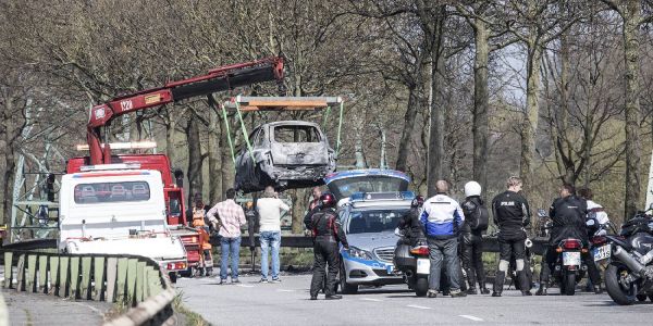 Motorradfahrer schauen zu, wie das Fahrzeug und die Harley an der Unfallstelle geborgen werden. Foto: André Zand-Vakili Motorrad und Auto gehen nach Zusammenstoß in Flammen auf