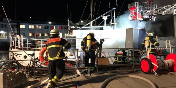 Einsatzkräfte der Feuerwehr bei den Löscharbeiten. Foto: pw Binnenhafen: Feuer auf historischem Wohnschiff am Lotsekai
