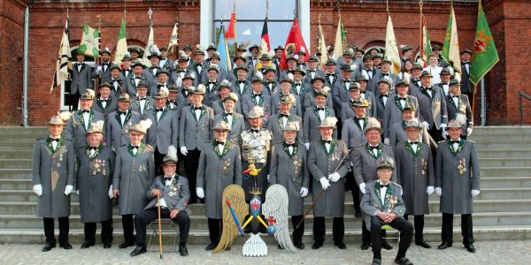 Die Mitglieder der Schützengilde traten am Mittwoch mit ihrem Regenten Sven Kleinschmidt (Mitte vorn) zum traditionellen Gildefoto vor dem Haupteingang der TUHH an. Foto: Christian Bittcher Schwitzen für die Fotografen: Das große Gildefoto ist im Kasten