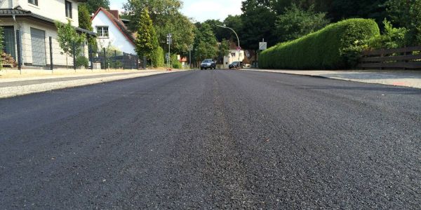 Schwarz und glatt: Der Langenberg bekam doch schon heute seine Kalt-Asphaltschicht. Foto: Christian Bittcher Neuer Asphalt in Eißendorf: Hitze sorgt für Termin-Wirrwarr