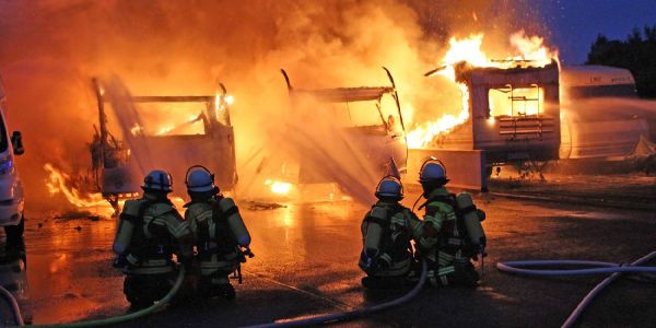 Die Lichterloh brennenden Wohnwagen werden gelöscht. Foto: Matthias Köhlbrandt Meckelfeld: Wohnwagen und Wohnmobil gingen in Flammen auf