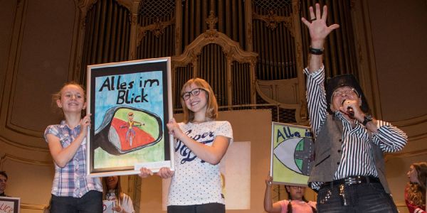 Auf der Bühne wurden Christine Kollecker (11) und Lea Tietze (12) von Peter Sebastian als Siegerinnen gekürt. Foto: André Zand-Vakili Plakatwettbewerb