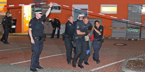 Polizisten bringen den Festgenommenen zum Peterwagen. Foto: André Zand-Vakili Festnahme