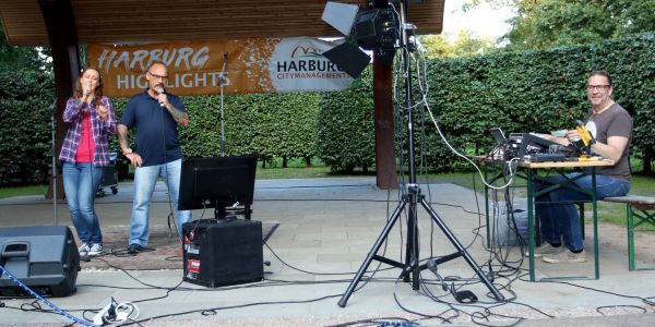 Karaoke auf der Freilichtbühne: Mr. Ballroom Heimo Raddemaker (rechts) an den Reglern, Nadine und Enrico Senkpiel am Mikrofon. Foto: Christian Bittcher Schräge Töne und echte Talente: Karaoke auf der Freilichtbühne