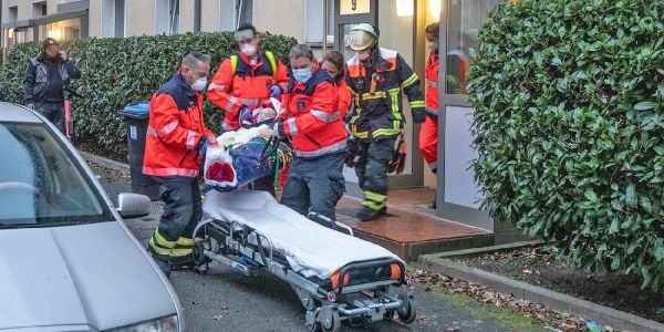 Einsatzkräfte bringen die schwer verletzte Frau aus dem Haus. Foto: André Zand-Vakili Messerstecherei