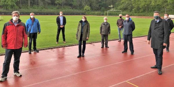 Metin Hakverdi (v.l.), Holger Böhm, Mark Schütter, Dr. Anke Jobmann, Reinhold Stehr, Henning Reh, Mark Schepanski, Dr. Andreas Dressel und Sebastian Alsgut auf der Sportanlage Opferberg. Foto: HNT Finanzsenator bei der HNT: Sportplatz Opferberg soll Sportpark werden