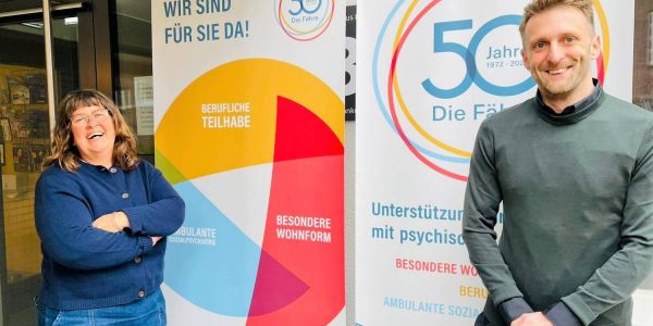 Die Geschäftsführung der Fähre, Maik Niestreu und Gundula Hildebrandt, vor dem Jubiläums-Logo. Foto: privat Erfolgsgeschichte: Die Fähre in Heimfeld hilft seit 50 Jahren psychisch Erkrankten