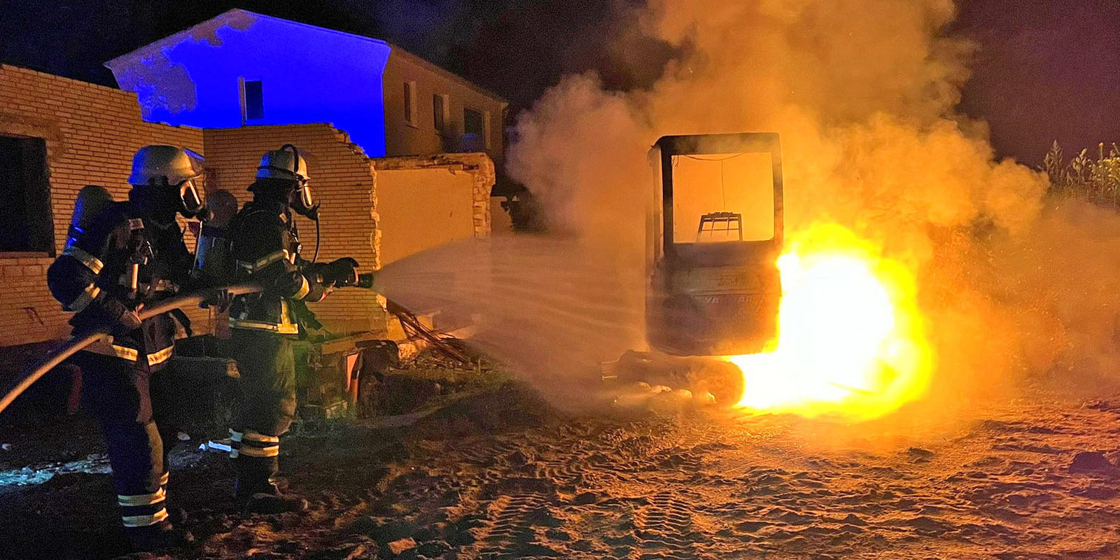 Feuerwehrleute löschen den brennenden Minibagger. Foto: Lenthe-Medien