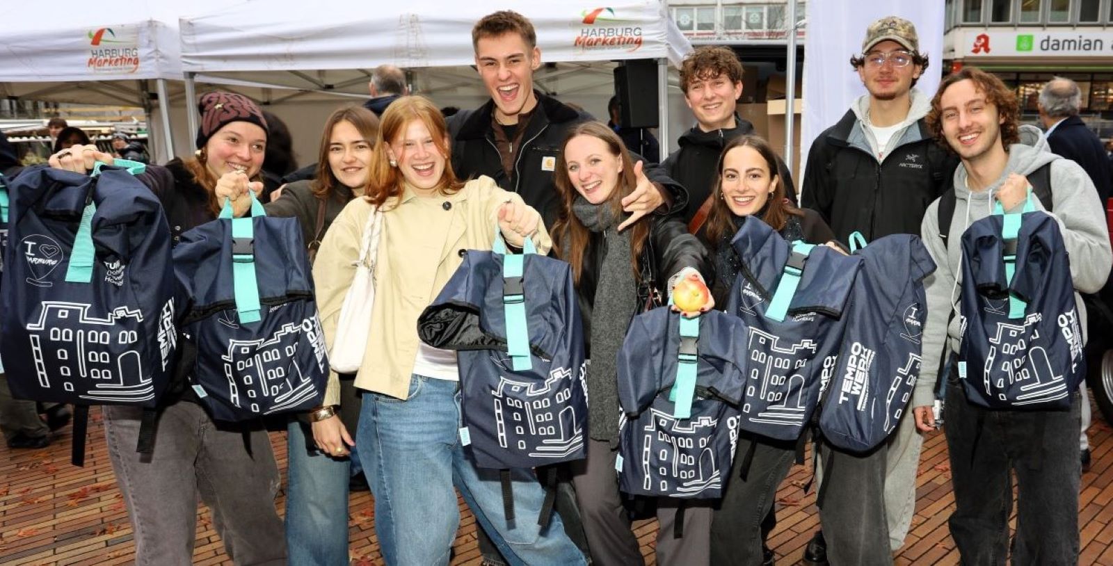 Freude über die neue Kult-Tasche: Studienbeginn auf dem Harburger Wochenmarkt. Foto: Christian Bittcher