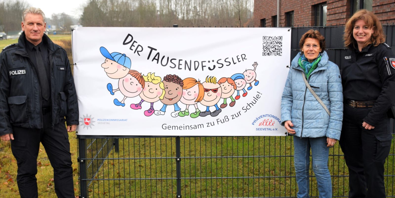 Der Leiter des Polizeikommissariats Seevetal, Erster Polizeihauptkommissar Holger Guse, mit Silke Lührs aus dem Vorstand des Präventionsrats und Polizeihauptkommissarin Stephanie Jahnert am neu installierten Banner vor der Dienststelle. Foto: Polizei