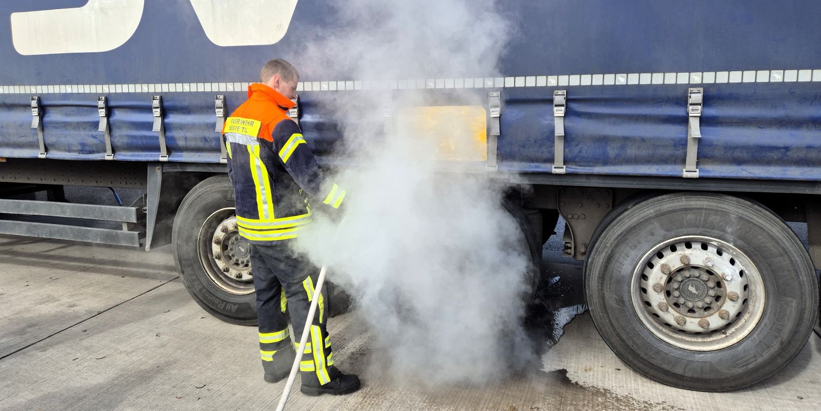 An diesem Sattelzug war eine Bremse heiß gelaufen.  Mit einem D-Strahlrohr kühlten die Feuerwehrleute die heiß gelaufene Bremse herunter. Foto: Sebastian Schulz, FF Maschen