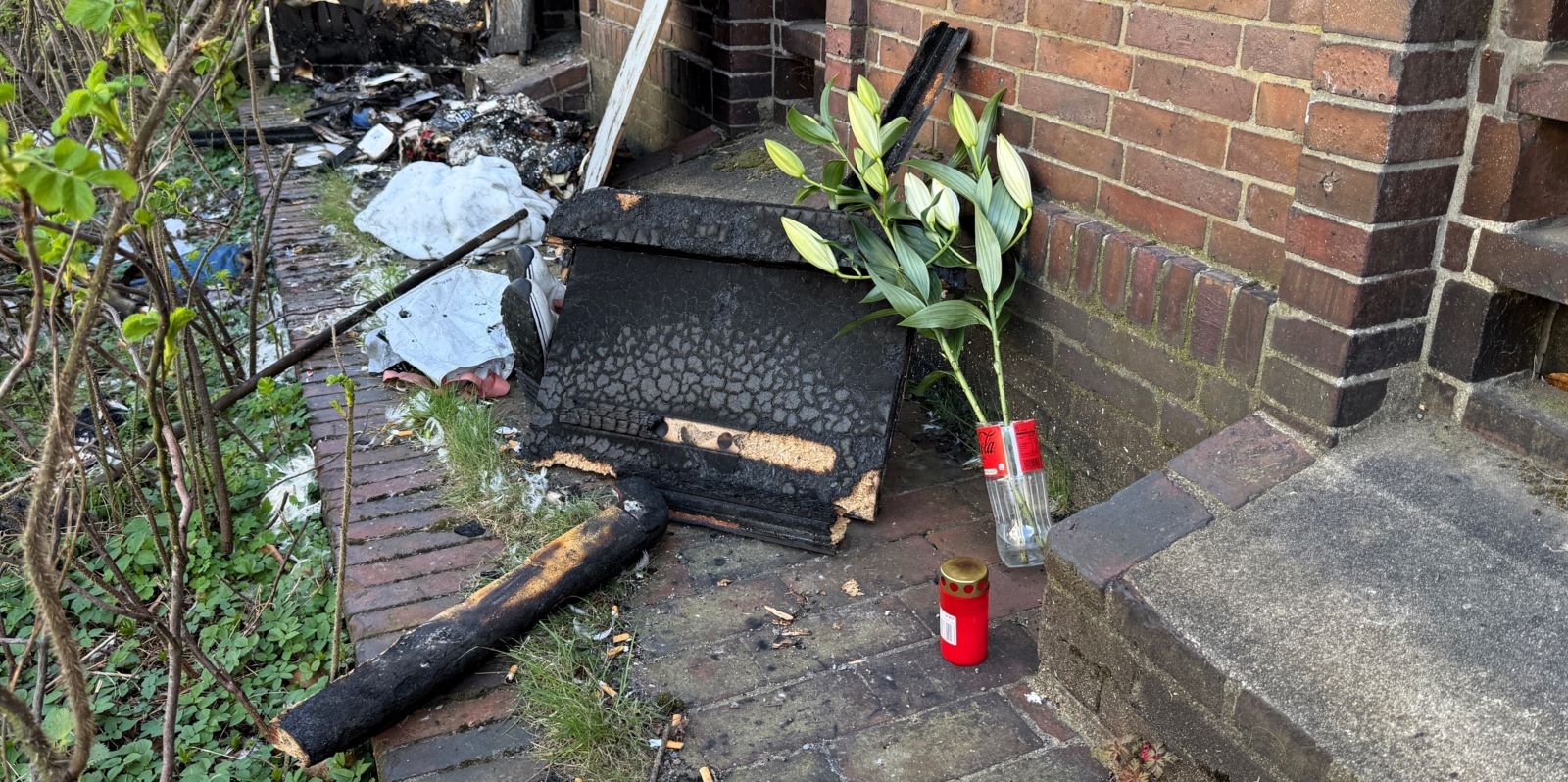 Trauer in der Woellmerstraße: Vor der Tür haben Nachbarn eine Kerze aufgestellt und Blumen niedergelegt. Foto: Lenthe-Medien Vor der Tür haben Nachbarn eine Kerze aufgestellt und Blumen niedergelegt. Foto: Lenthe-Medien