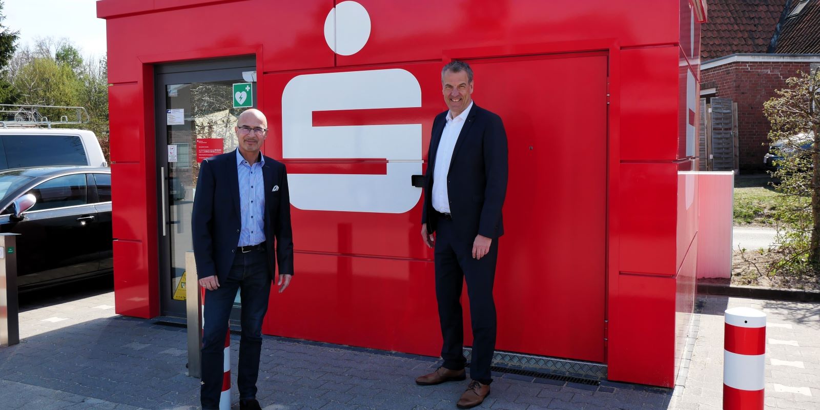 Andreas Sommer (Vorstandsvorsitzender, rechts) und Thomas Müller (Regionalleiter) haben den modernen SB-Pavillon der Sparkasse Harburg-Buxtehude in Holm-Seppensen eröffnet. Foto: Sparkasse