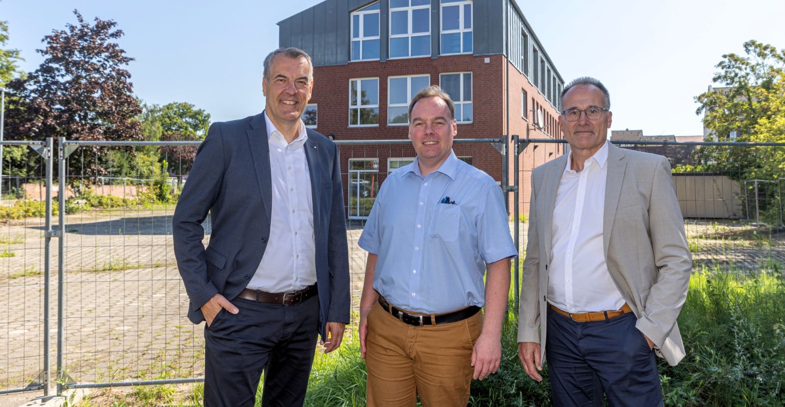 Andreas Sommer (Sparkasse Harburg-Buxtehude), André Wiese (Stadt Winsen) und Jörg Ruschmeyer (May &amp; Co.) vor dem Gelände des ehemaligen Pressezentrums, auf dem das neue Geschäfts- und Wohnhaus entsteht. Foto: Sparkasse