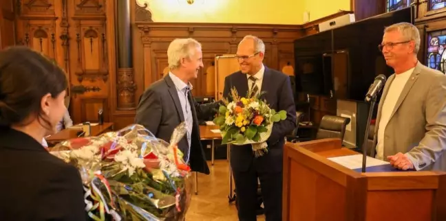 Blumen für den neuen Bezirksamtlseiter Christian Carstensen: Rainer Bliefernicht gehörte zu den ersten Gratulanten. Foto: Lenthe-Medien