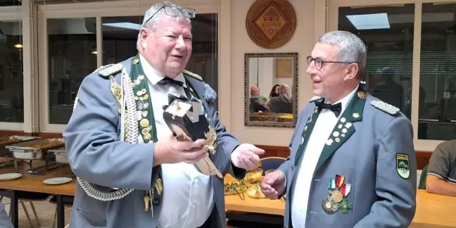 Der Vorsitzende der ehemaligen Könige, Gert Eggert, gratuliert Jens Kabuse zum Titel und überreicht ihm den Rest des hölzernen Vogels.  Foto: pr