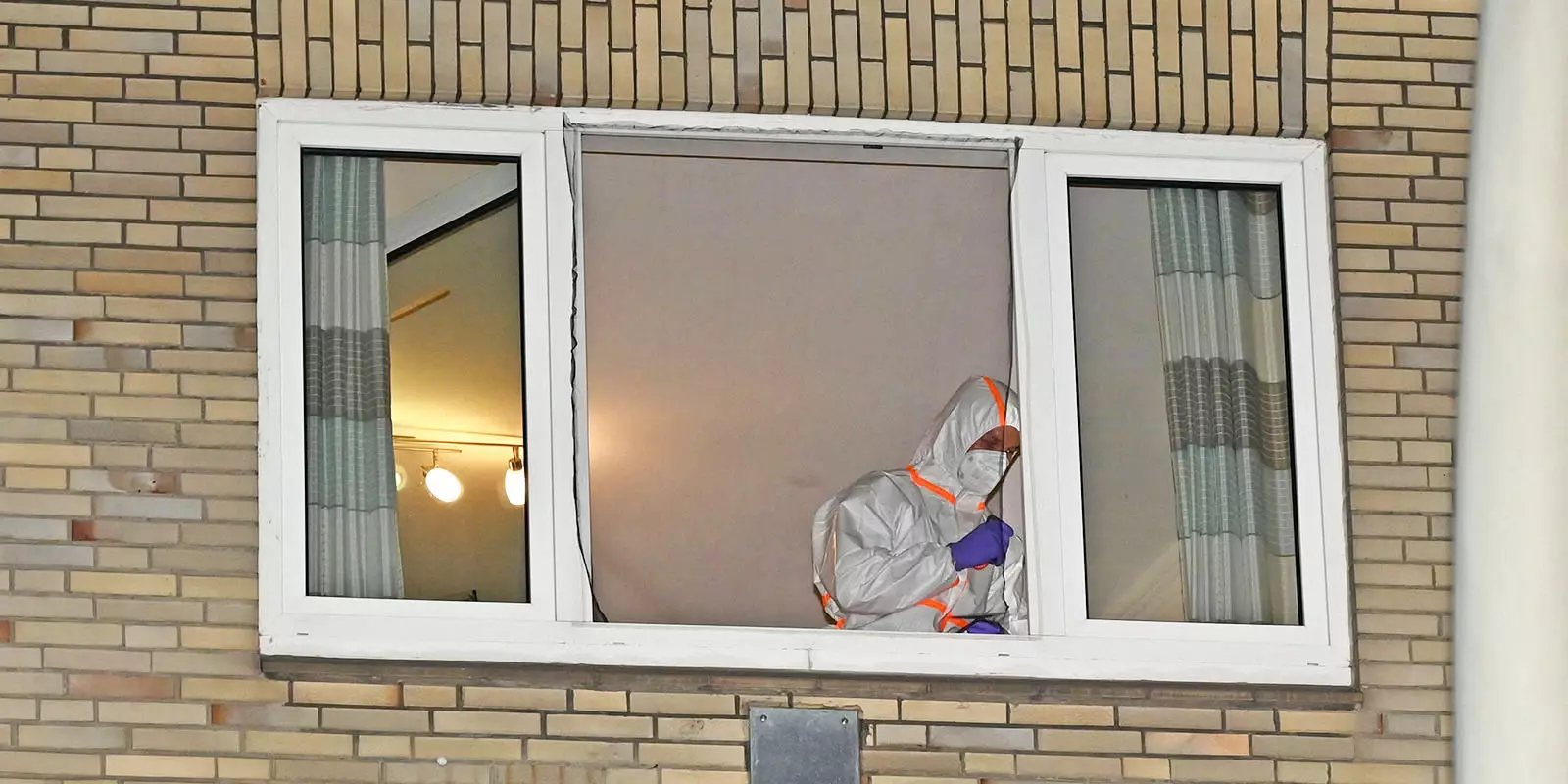 Ein Kripomann an dem Fenster, aus dem der Junge stürzte. Foto: Lenthe-Medien