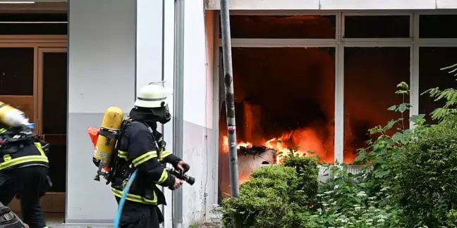 Feuerwehrleute vor dem brennenden Unrat im Erdgeschoss. Foto: Lenthe-Medien