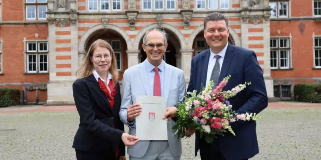 Mit der Ernennungsurkunde vor dem Rathaus: Der neue Bezirksamtsleiter Christian Carstensen (Mitte) mit Anke Jobmann und Senator Andreas Dressel. Foto: Christian Bittcher
