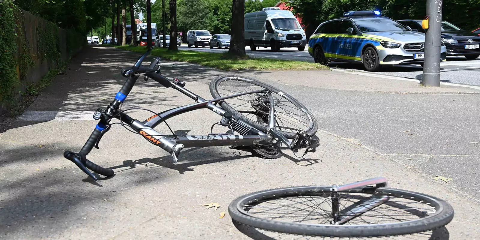 Eines der beiden zusammengestoßenen Fahrräder liegt mit abgerissener Gabel auf dem Fußweg. Foto: Lenthe-Medien