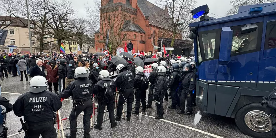 Polizisten und Demonstranten stehen sich vor der Kirche in Heimfeld gegenüber. Foto: zv