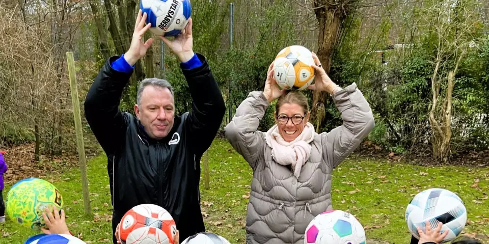„Könnt ihr auch alle auf einem Bein hüpfen und den Ball dabei hochhalten?“ Markus Kranz, „Fußball Monster“, und DRK-Kitaleiterin Steffi Wolgast-Knipschild an der Scheeßeler Kehre  Credit: DRK Harburg