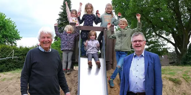 Bernd Beiersdorf (Bürgermeister von Bendestorf) und Cord Köster (Stiftung für Stifter der Sparkasse) weihten die neue Hangrutsche gemeinsam mit den begeisterten Kindern ein. Foto: Sparkasse