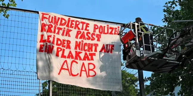 Einsatz für die Drehleiter: Das Transparent am Hermann-Krüger-Platz wird abgenommen. Foto: Lenthe-Medien