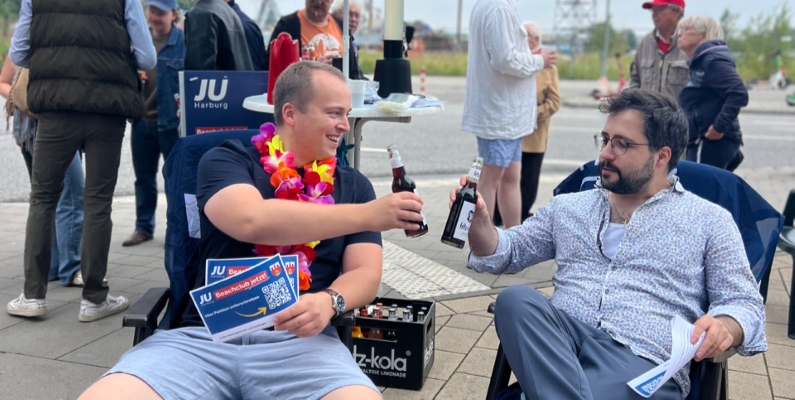 Steffen Reder (Kreisvorsitzender JU Harburg) und Thore Bliefernicht stoßen mit einer Cola auf die Aktion an. Foto: pr