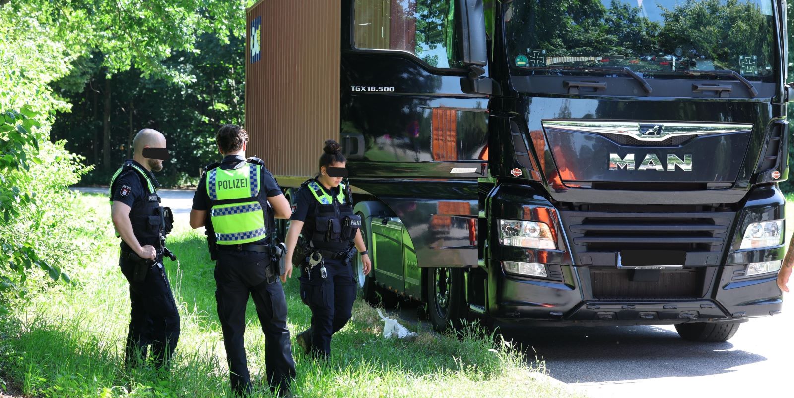 Polizisten an dem abgestellten Lkw, in dem die Leiche gefunden wurde. Foto: Lenthe-Medien