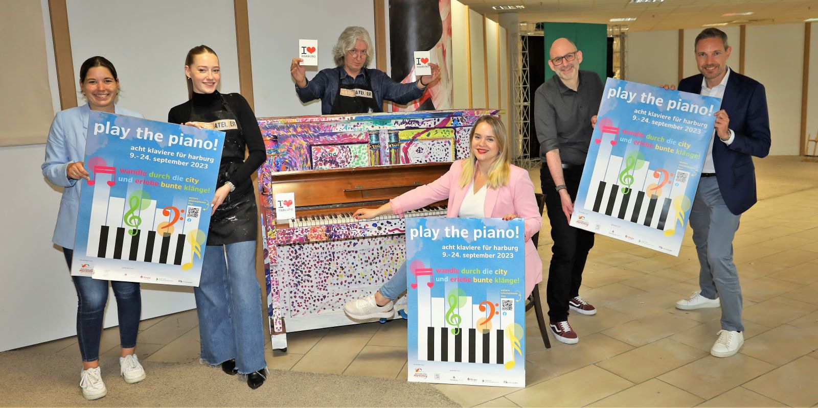 Play the Piano: Darauf freuen sich Louisa Knipschild (v.l.), Valerie Stricker und Sly vom Habibi-Atelier, Antonia Marmon, Dennis Imhäuser (Beziksamt) und Marcel Sluppke von der Haspa. Foto: Christian Bittcher